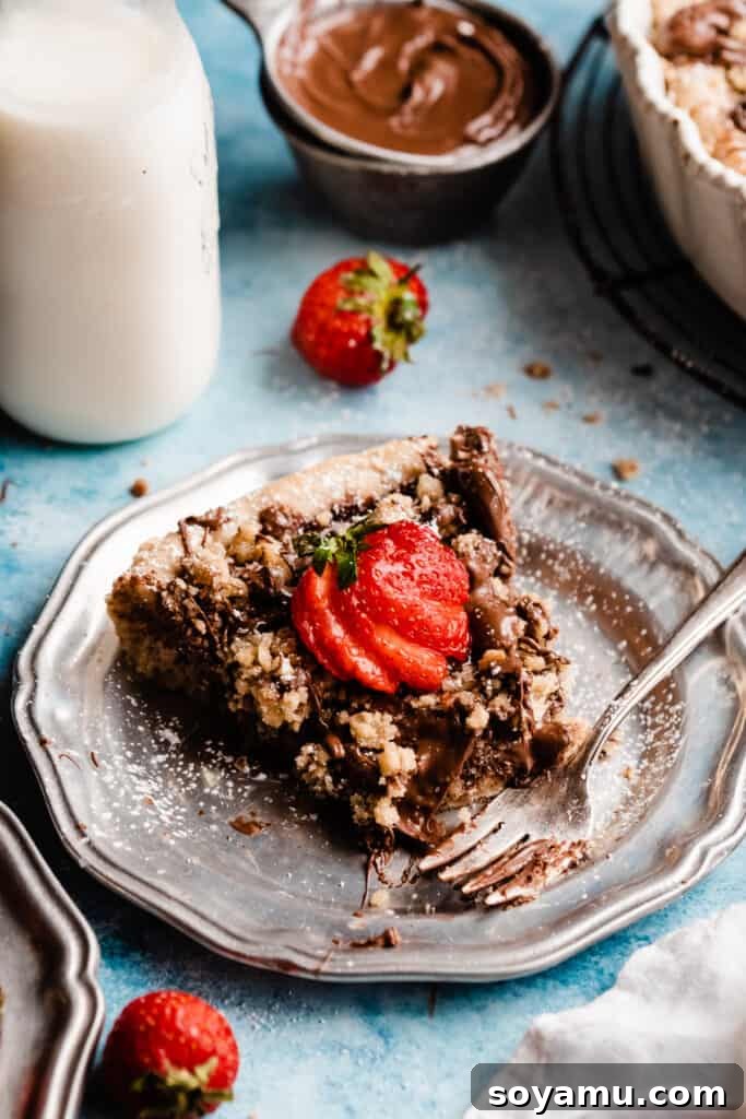 A slice of nutella pizza on a plate with a bite missing.