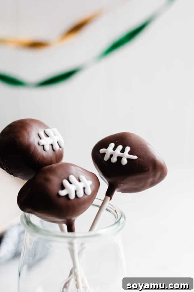 Game-day ready: perfectly decorated football cake pops Decorated football-shaped chocolate cake pops with white icing laces.