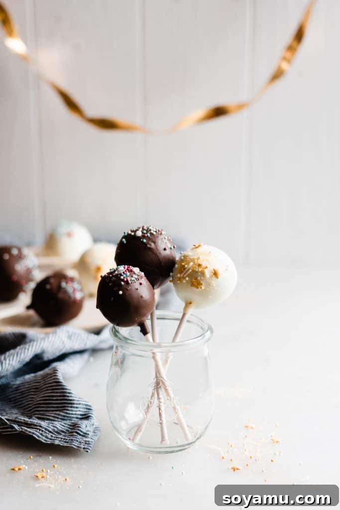 Detailed view of a chocolate cake pop with decorative sprinkles A close-up of a chocolate cake pop adorned with sprinkles, ready to be enjoyed.