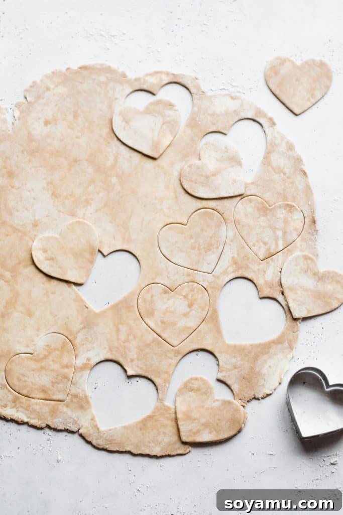 Heart-shaped pie dough Pie dough rolled out and expertly cut into heart shapes with minimal waste, ready for assembly.