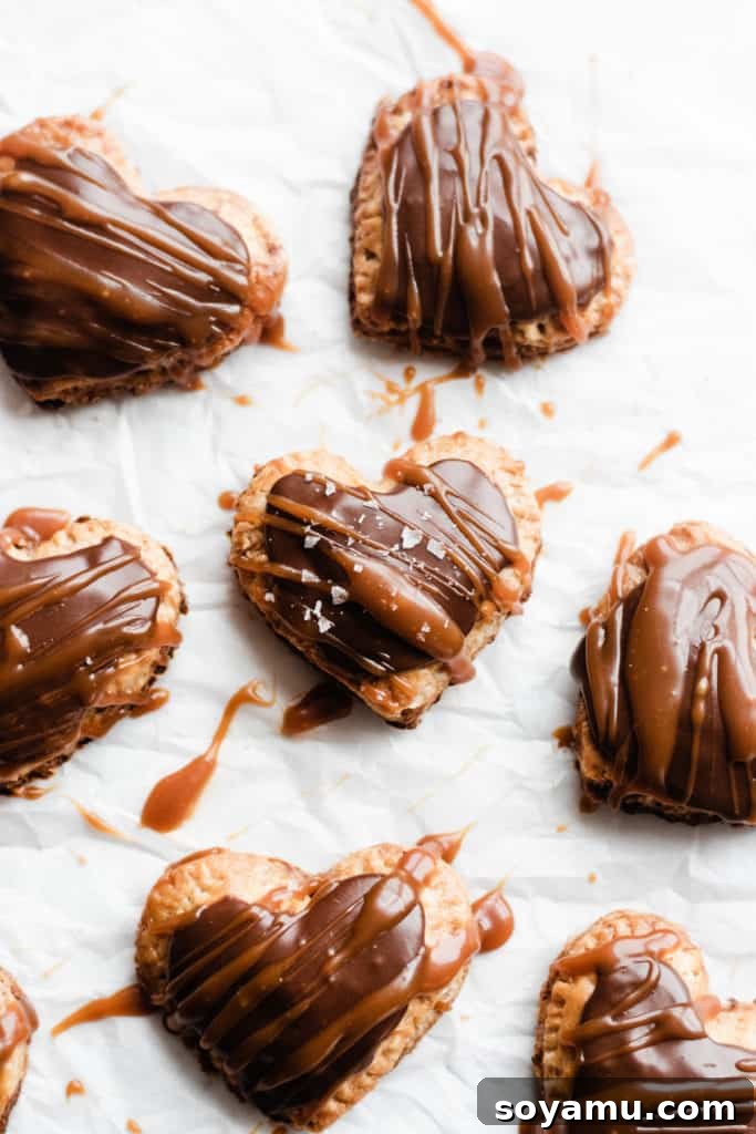 Nutella Pop Tarts on parchment Heart-shaped homemade Nutella Pop Tarts cooling on parchment paper, showcasing their perfect golden crusts.