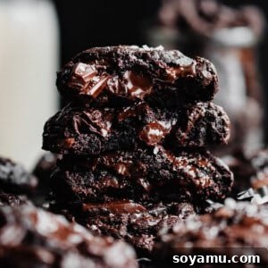 A stack of triple chocolate cookie halves, showing the fudgy insides.