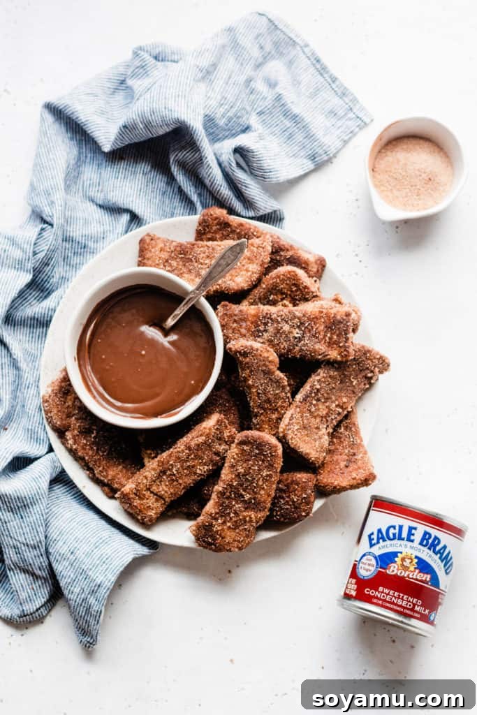 A plate of freshly made Churro French Toast Sticks, ready for dipping Churro French Toast Sticks with bowl of chocolate sauce and cinnamon