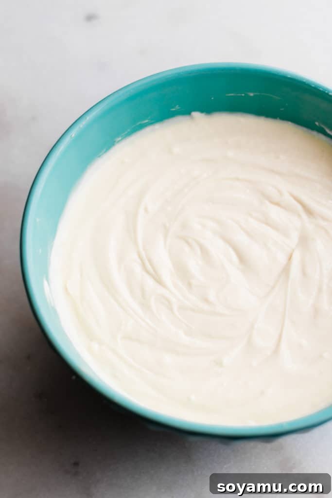 Silky Smooth Cheesecake Batter A smooth, creamy vanilla cheesecake batter filling a large mixing bowl, perfectly blended and ready for the next step of baking.
