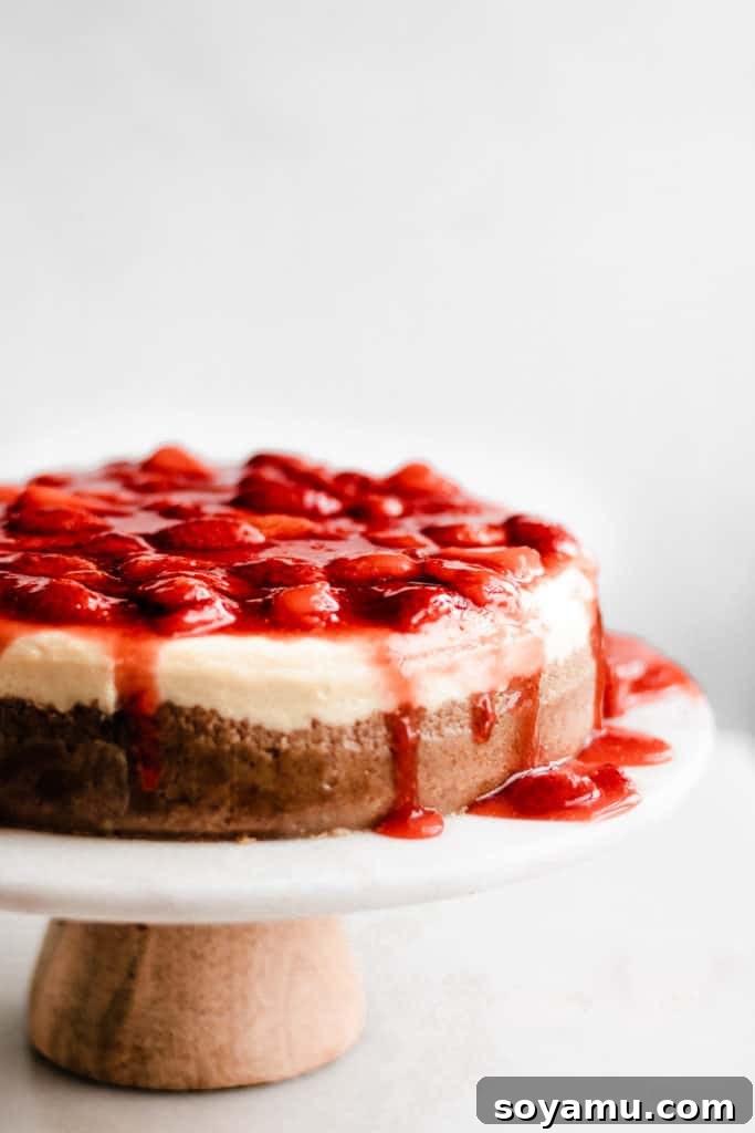 Strawberry Cheesecake Ready to Serve A beautifully baked classic cheesecake, completely covered with a vibrant and glossy homemade strawberry sauce, ready to be sliced and served.