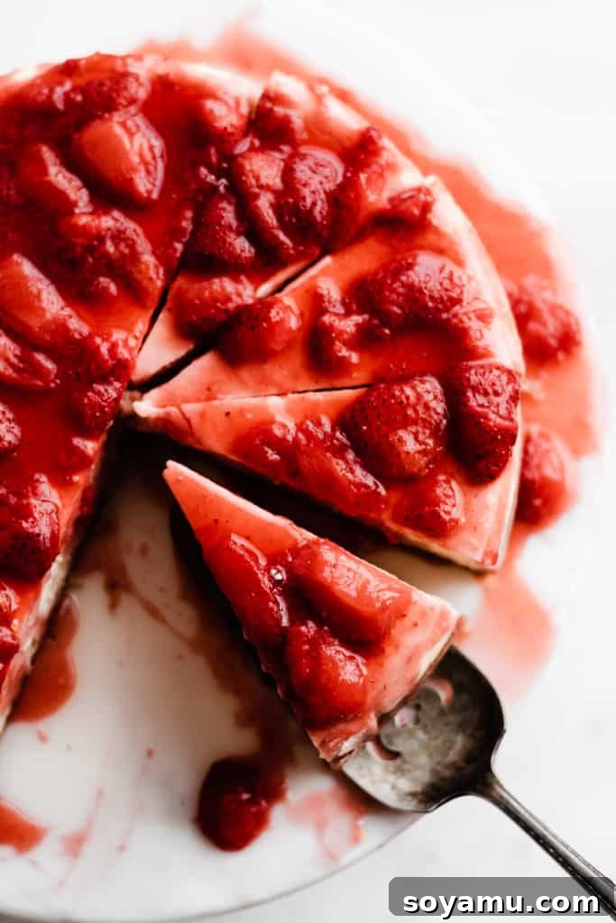 Top-Down View of Sliced Strawberry Cheesecake An overhead view of a whole strawberry cheesecake, with several perfect slices already cut and placed, showcasing its layers and vibrant topping.