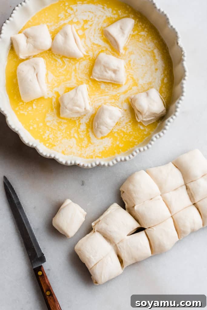 Pieces of Rhodes bread dough tossed in melted butter inside a round baking pan.