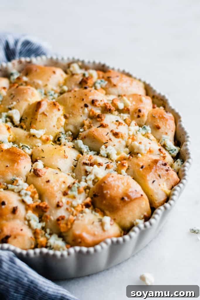 Close-up of fluffy cheesy baked bread bites, showcasing the gooey melted cheese and golden-brown crust.