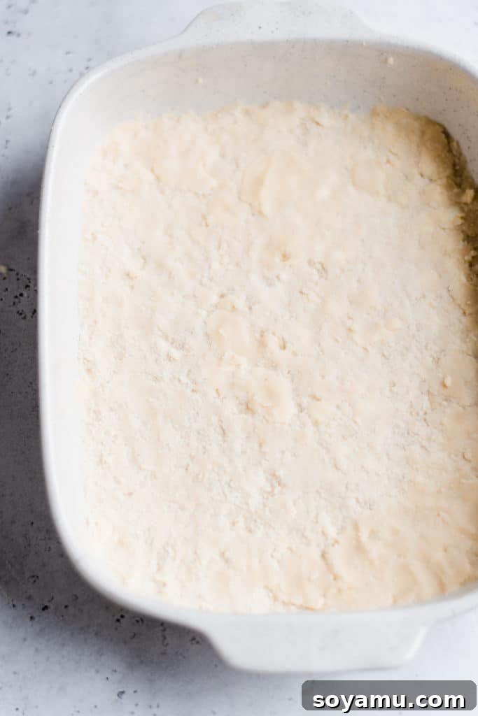 Rhubarb Crumble Cake 4 Unbaked shortbread crust pressed evenly into a rectangular baking dish, ready for baking. Essential first step for a delicious Rhubarb Torte.