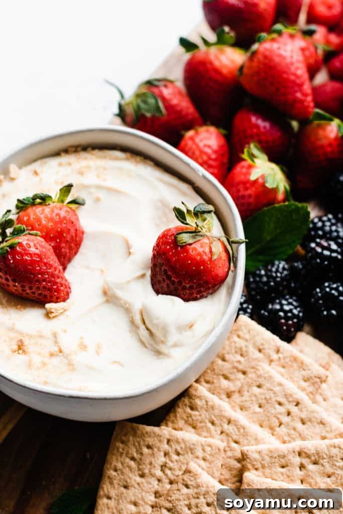 Strawberry Dipped in Cheesecake Dip - A delicious, close-up view of the perfect sweet bite. A close-up shot of a plump, juicy strawberry being perfectly dunked into the smooth, creamy cheesecake dip, highlighting its irresistible texture.