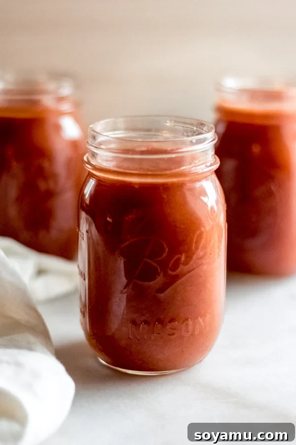 Homemade applesauce in glass jars on a rustic wooden background, ready for a cozy fall day.