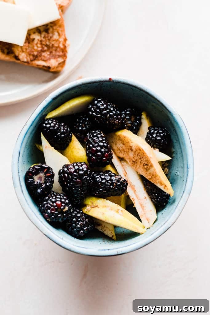 Indulgent Vanilla Rum French Toast with Blackberries and Pears 5 A blue bowl of blackberries and pear slices sprinkled with cinnamon, brown sugar, and rum