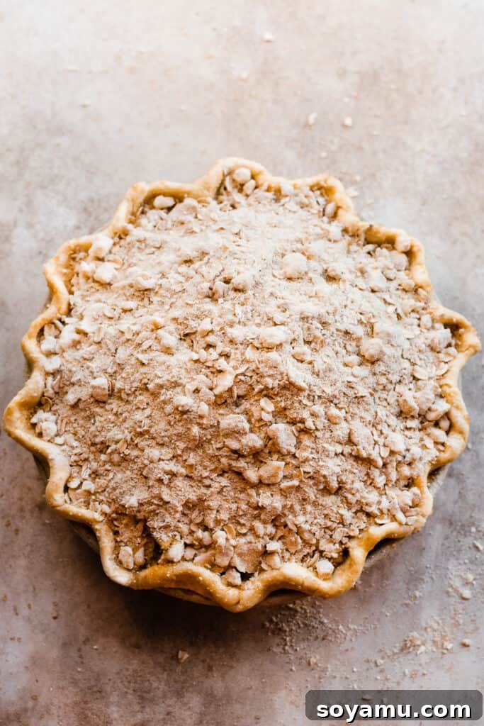 The Easiest 3-Ingredient Pie Crust Ever 13 An unbaked pie topped with crumble.