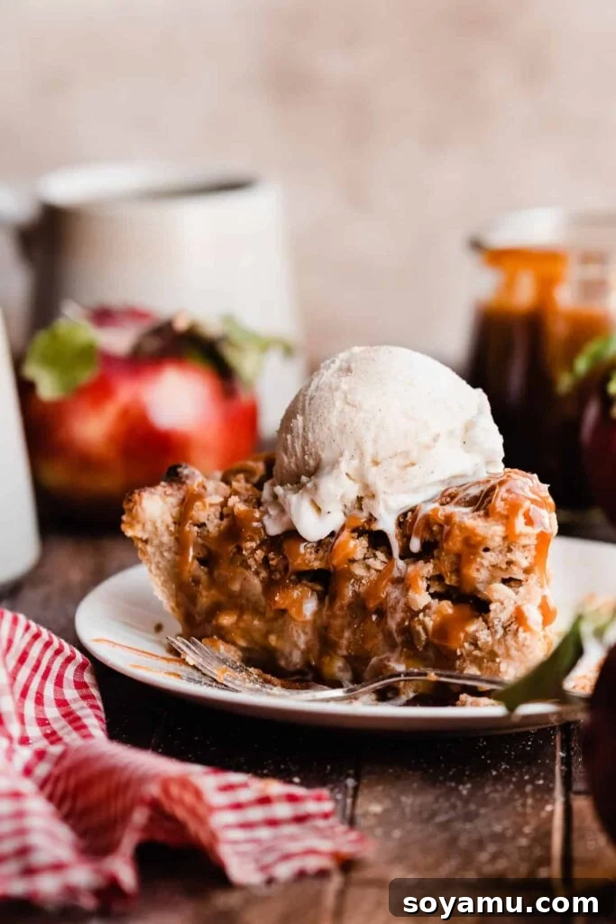 The Easiest 3-Ingredient Pie Crust Ever 17 A slice of apple pie baked inside buttery, flaky homemade pie crust, with caramel sauce and a scoop of ice cream.