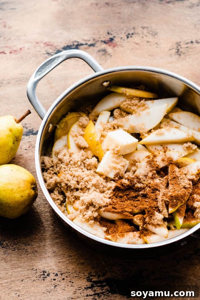 Decadent Deep Dish Pear and Cinnamon Crumble Pizza 5 A pan with fresh pear slices, brown sugar, a blend of fall spices, and melted butter, ready to be cooked for the filling