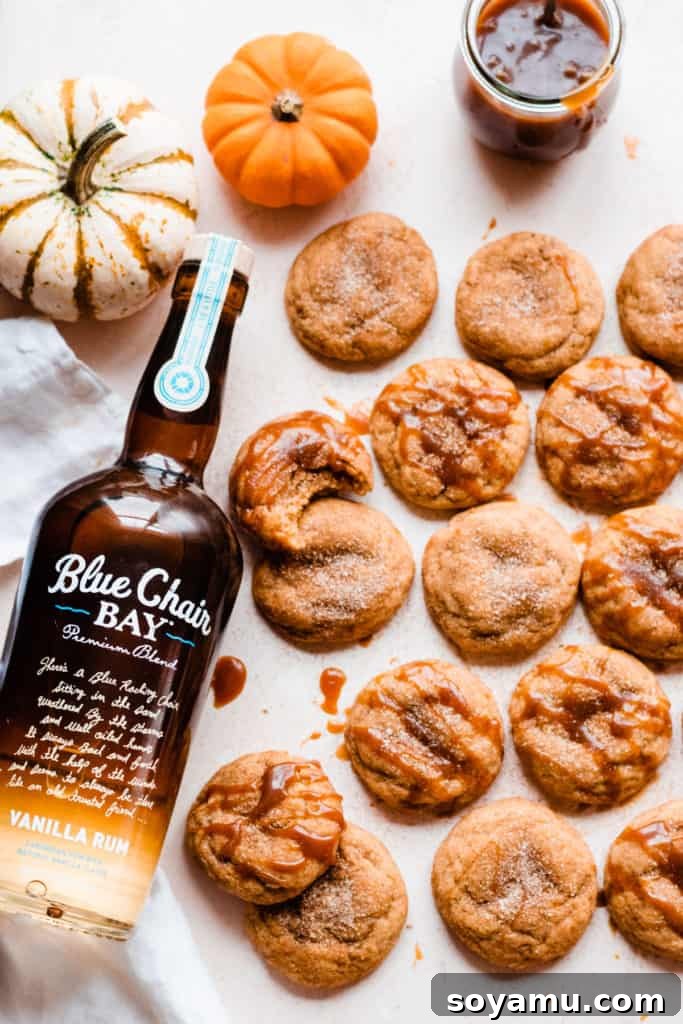 Pumpkin snickerdoodles arranged artfully on a light surface with autumnal decorations, highlighting their rich color and inviting texture