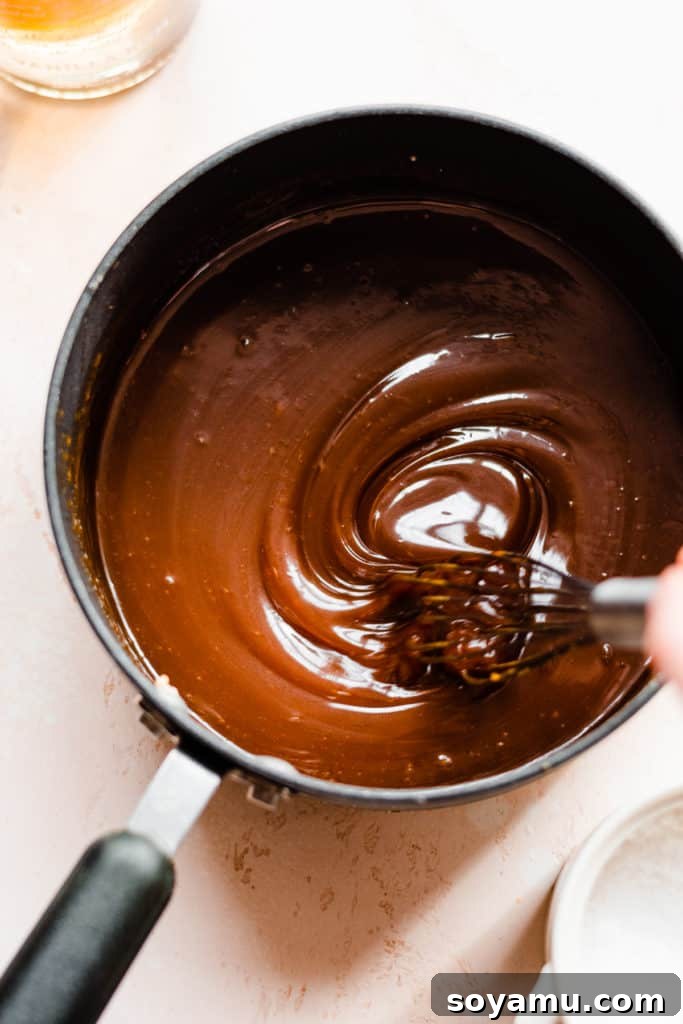 A bowl of caramel sauce being whisked up to a smooth, luscious consistency