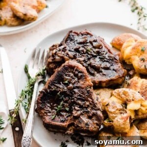 Lamb chops on a plate with smashed potatoes.