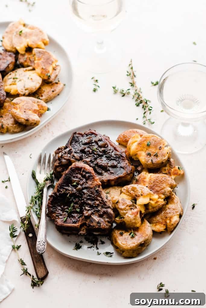 Tender Lamb Chops with Shallot-Thyme Pan Sauce and Creamy Garlic Smashed Potatoes 10 A close-up of a plated lamb chop and garlic smashed potatoes, showcasing the appealing texture and golden crust of both components.