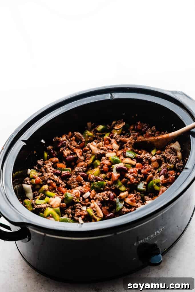 Effortless Slow Cooker Chili Perfection 5 A top-down view of a slow cooker filled with all the chili ingredients, now thoroughly stirred and ready for the long cooking process.