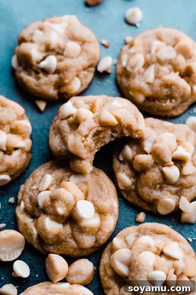 Soft and thick white chocolate macadamia nut cookies on a vibrant blue surface, highlighting their rich texture and abundant inclusions.