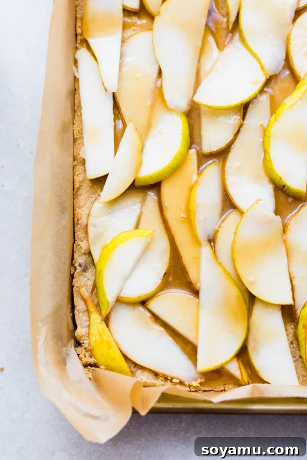 Incredibly Delicious Pear Crumble Bars - Pears and caramel sauce on the crumble base for dessert bars. Sliced pears layered on a crumble crust, drizzled generously with homemade caramel sauce.