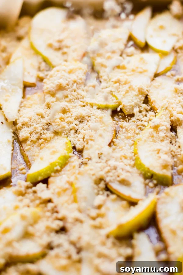 Incredibly Delicious Pear Crumble Bars - Crumble topping added to pear and caramel dessert bars. Crumbly topping sprinkled over the pear and caramel filling, ready for baking.