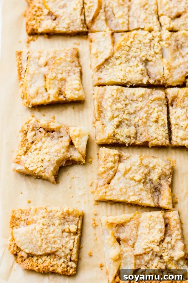 Incredibly Delicious Pear Crumble Bars - Pear crumble bars arranged on a serving board. Several pear crumble bars arranged on a wooden board, showcasing their golden topping and juicy filling.