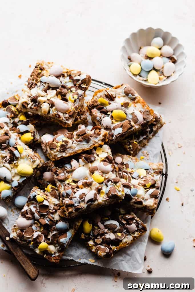 A beautifully presented platter of Seven Layer Bars, accompanied by a bowl of colorful Easter egg candies, ready to be enjoyed.