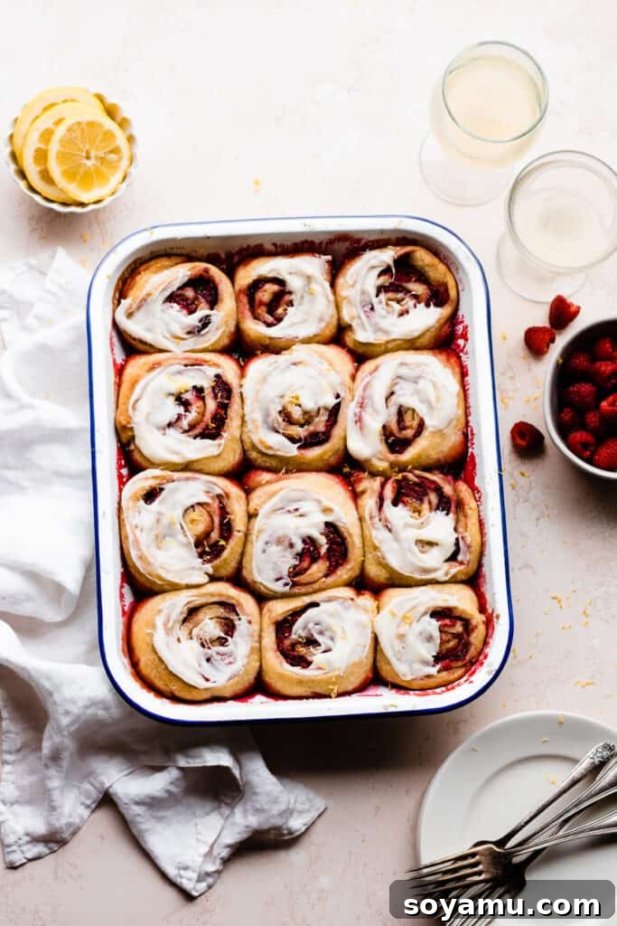 Tangy Raspberry Lemon Morning Buns with Cream Cheese Glaze 10 A baking pan filled with freshly baked Raspberry Lemon Sweet Rolls, generously covered with smooth cream cheese icing.