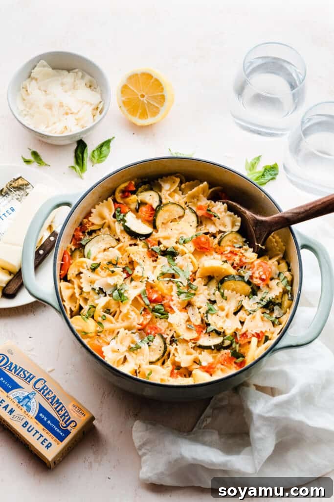 A second view of a pot of pasta with zucchini, tomatoes, and fresh basil, invitingly plated.