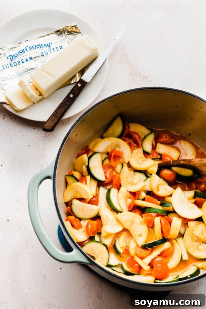 A pan showcasing the perfectly cooked and softened zucchini and tomatoes, glistening with butter.