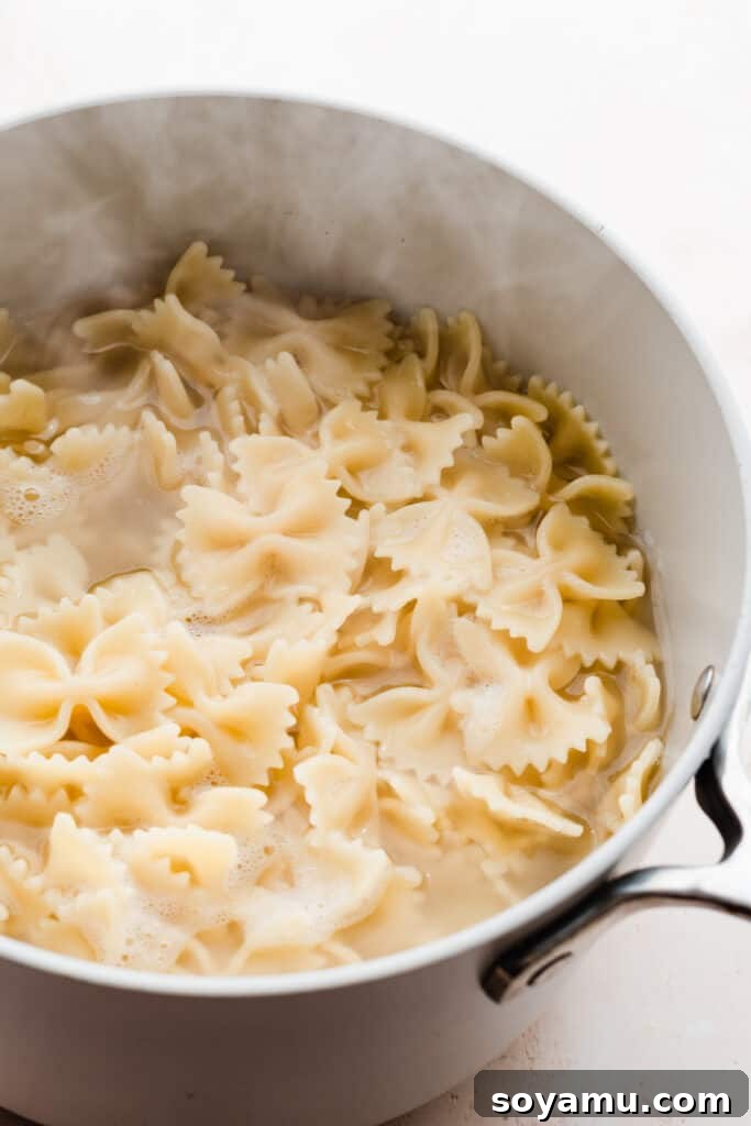 A steaming pot of perfectly cooked bowtie pasta, ready to be drained and mixed.