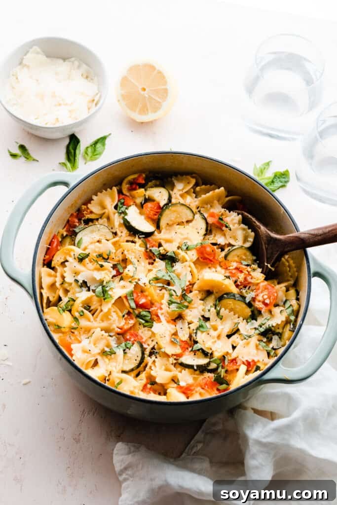 A final, appealing shot of the pot of lemon butter pasta with zucchini, tomatoes, and fresh basil, ready for serving.
