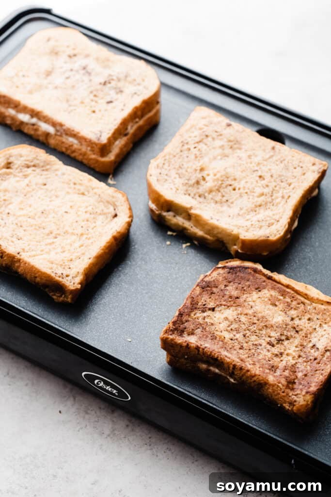 Decadent Stuffed French Toast 6 French toast slices cooking on a griddle, turning golden brown.