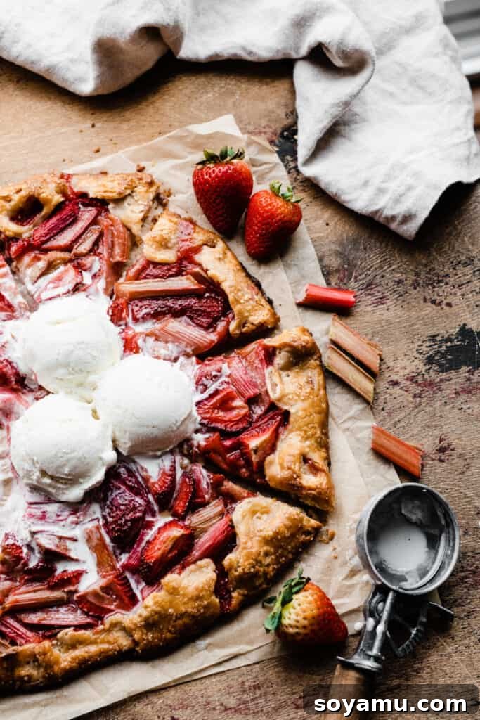 A beautifully sliced galette topped with generous scoops of vanilla ice cream, artfully arranged on a wooden surface, ready to be enjoyed.