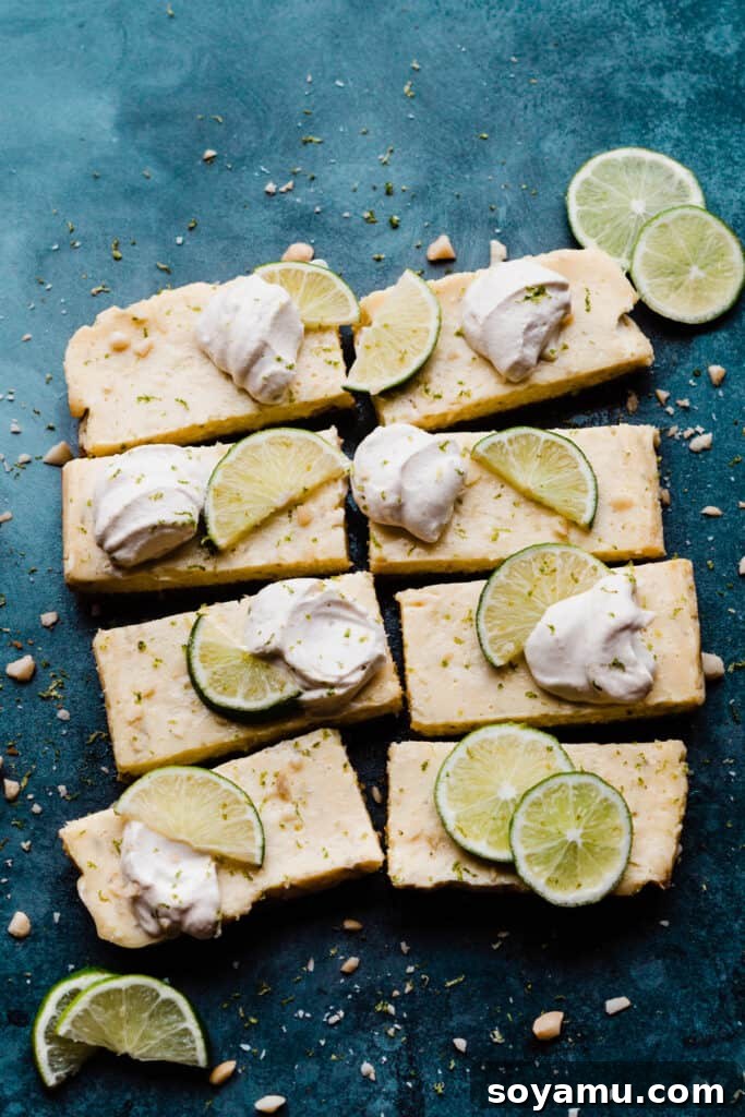 Tropical Key Lime Macadamia Bars 10 Key Lime Pie Bars topped with whipped cream, lime slices, and lime zest.