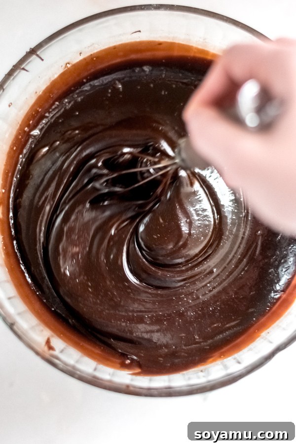 Mixing the Decadent Chocolate Bourbon Pecan Pie Filling Chocolate bourbon pecan pie filling mixing in a bowl.