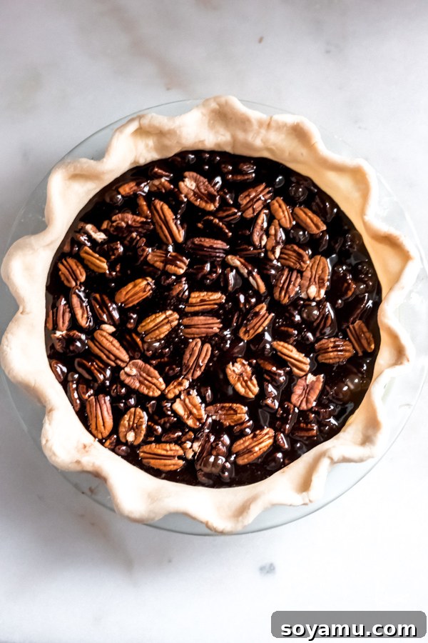 Adding Pecans to the Chocolate Bourbon Filling Pecans placed on top of pie filling.
