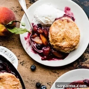 Plates of juicy blueberry peach cobbler, beautifully plated and ready to be served, highlighting its rich colors and texture.