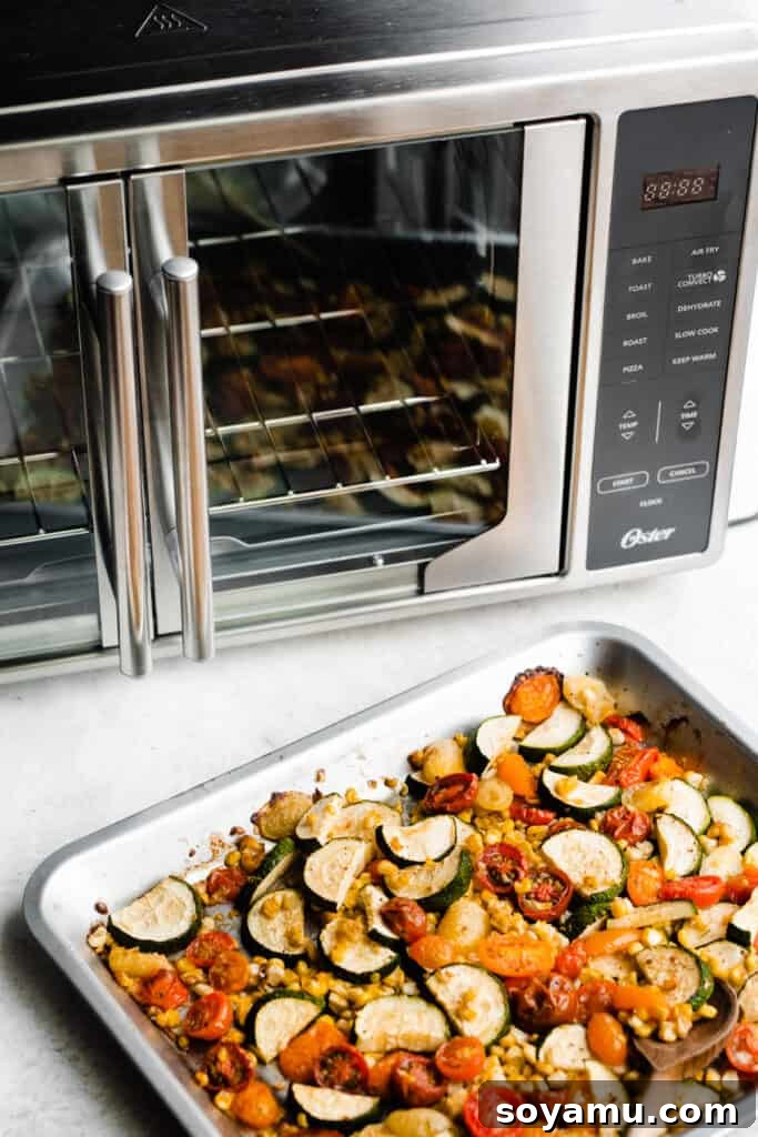 Vibrant Roasted Vegetables for Meal Prep 3 A pan of the roasted veggies sitting next to a sleek French door air fryer oven.