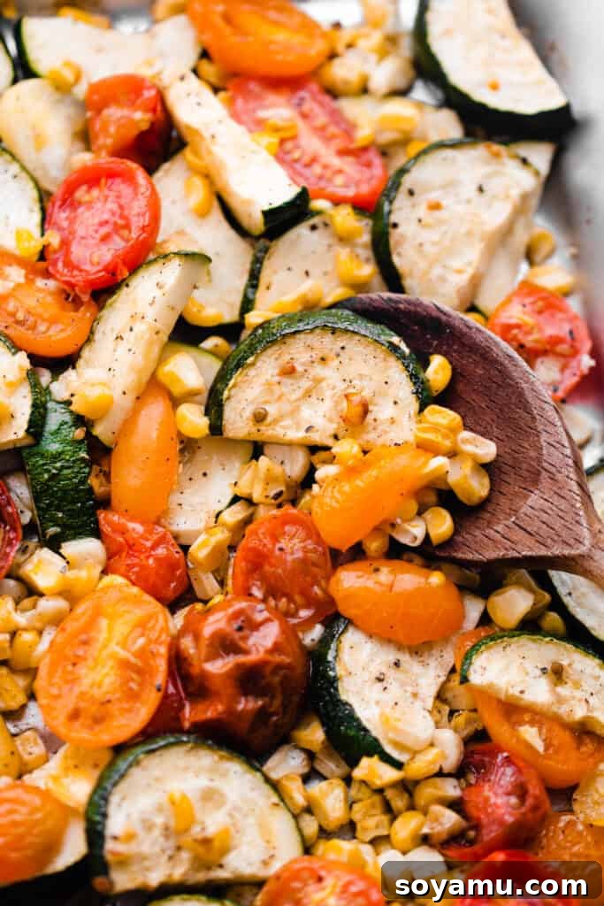 Vibrant Roasted Vegetables for Meal Prep 7 A spoon scooping into the pan of roasted veggies, showing their tender texture and rich color.