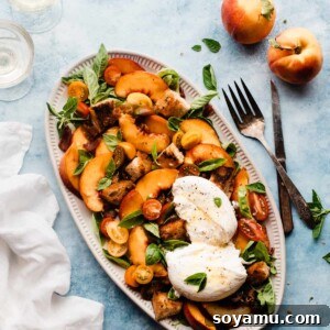A vibrant peach salad with burrata cheese, tomatoes, crispy bacon, and fresh basil artfully arranged on a platter, ready to be served.