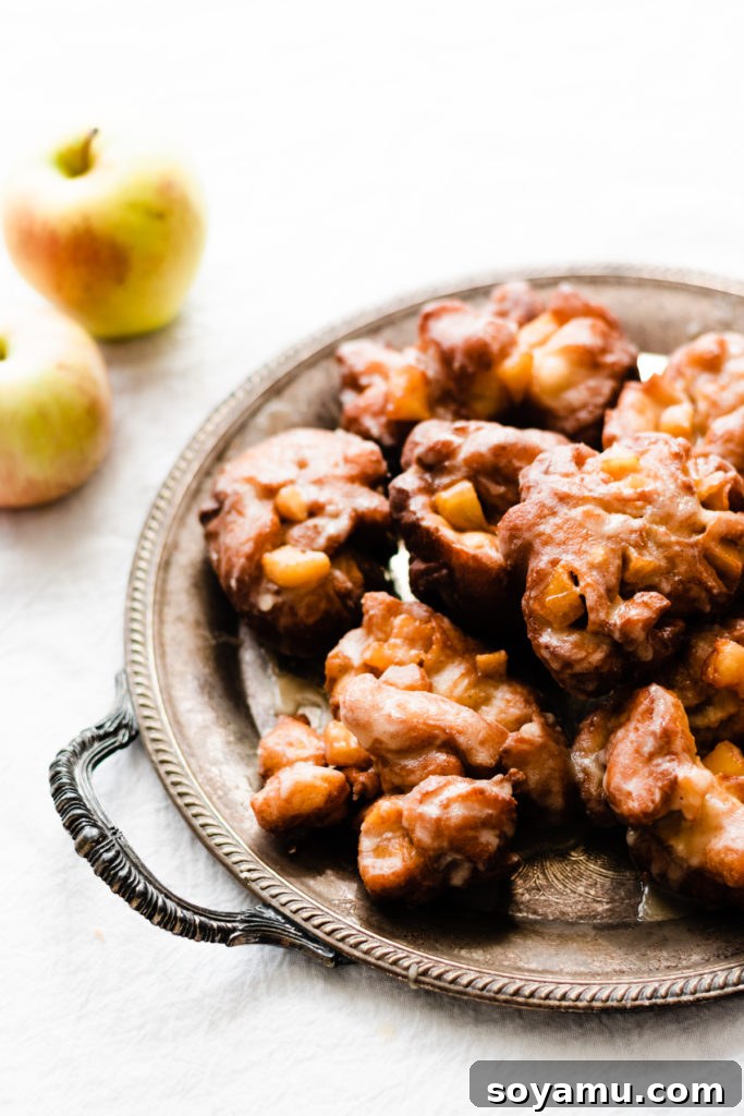 Autumns Best Apple Recipes Fresh from the Orchard 15 A delectable tray of golden-brown Homemade Apple Fritters, generously coated in a shimmering buttery maple glaze.