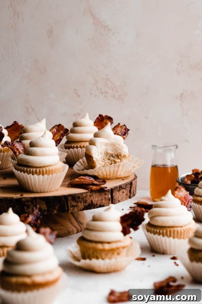 Brown Butter Maple Bacon Perfection 3 Maple Bacon Cupcakes on a wooden cake stand.