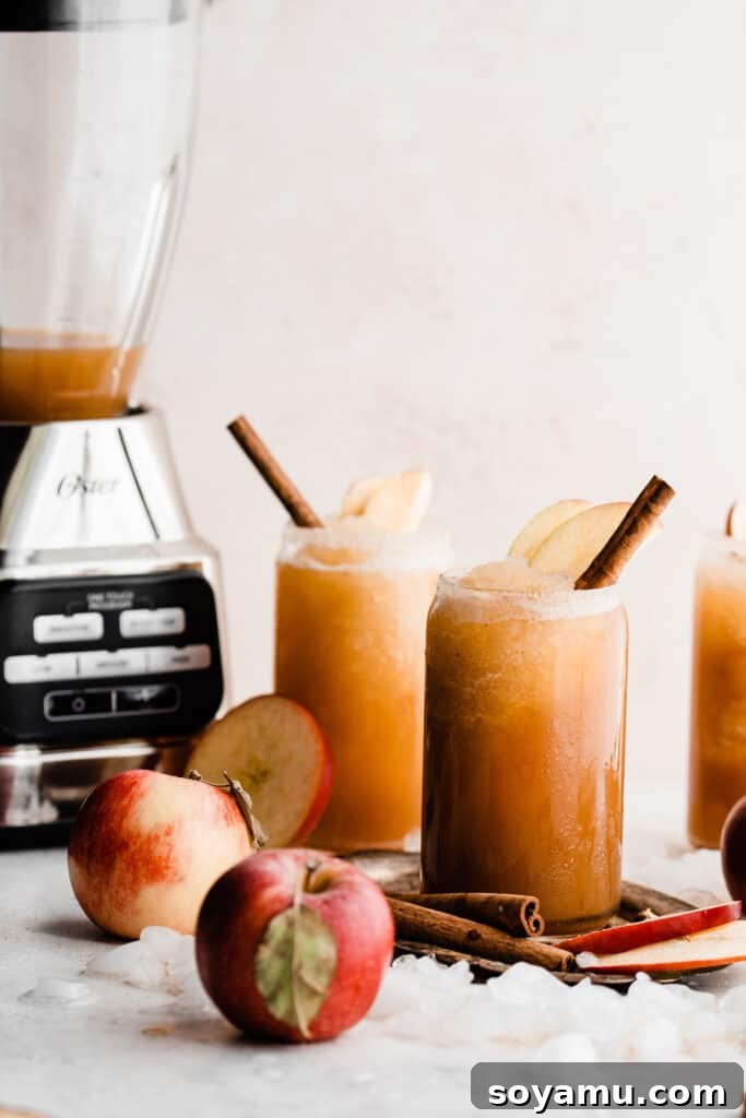 Spiked or Not Apple Cider Slushies 3 A blender and three glasses of apple cider slushies.