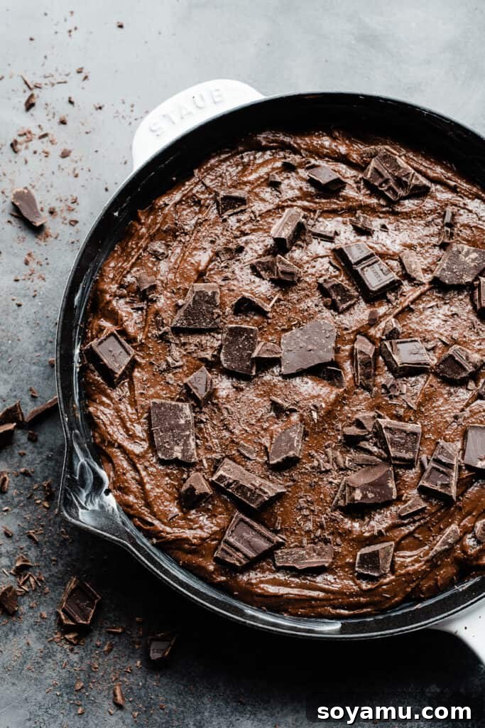 Ultimate Fudgy Triple Chocolate Skillet Brownie 6 An oven-safe skillet filled with rich brownie batter, generously topped with extra chocolate chunks before baking.