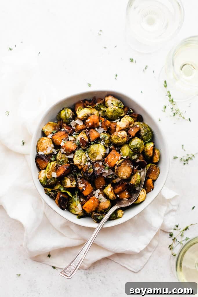 Sweet Maple Roasted Brussels Sprouts and Butternut Squash with Crispy Bacon 6 A rustic ceramic bowl overflowing with the warm, maple roasted Brussels sprouts, butternut squash, and crispy bacon, with a serving spoon nestled inside.