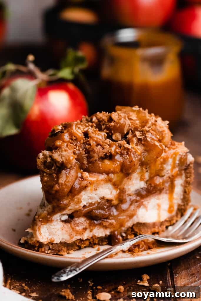 Decadent Salted Caramel Apple Pie Cheesecake 12 A close-up shot of a perfectly sliced piece of caramel apple pie cheesecake on a plate, highlighting the creamy layers, fruit, and toppings.