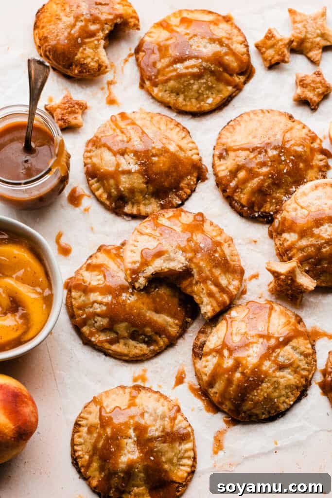 Salted Caramel Peach Mini Pies 9 Peach Hand Pies drizzled with caramel with little pie star cutouts scattered around.